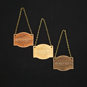 Laser engraved decanter tags made from cherry, maple and walnut reading "Bourbon" add a beautiful vintage touch to your bar
