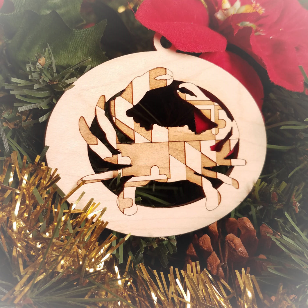 Laser engraved birch Christmas ornament featuring a blue crab with the Maryland state flag design