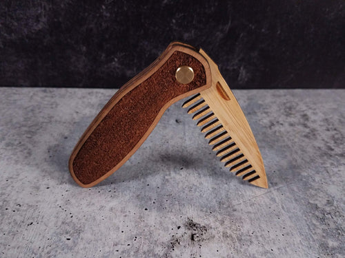 Folding tactical beard comb featuring a walnut handle laser engraved with a stipple pattern, and a bamboo ply blade